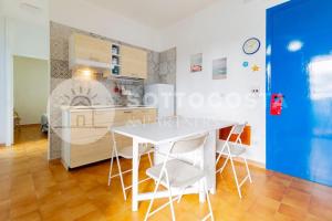 a kitchen with a white table and white chairs at Heavenly flat- Torre dell'Orso in Torre dell'Orso