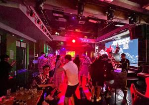 a group of people dancing in a bar at P Boutique Hotel - Grand World Phú Quốc in Phu Quoc