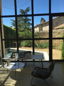 a living room with a table and chairs and a large window at My Home in lourmarin in Lourmarin