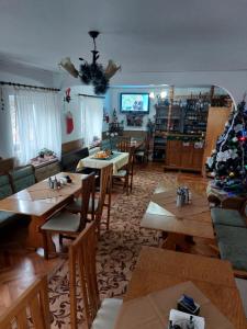 ein Wohnzimmer mit Tischen und einem Weihnachtsbaum in der Unterkunft Casa Ott in Prisaca Dornei