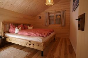 a bedroom with a bed in a log cabin at Hirschberghütte in Bizau