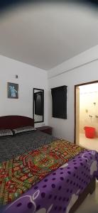 a bedroom with a bed with a colorful comforter at Durga budget stay in Munnar