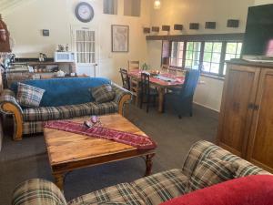 un soggiorno con divano e tavolo di Arden Country House BnB a Dunedin