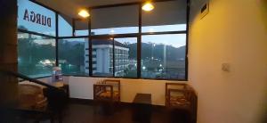 a room with a large window with a view of a city at Durga budget stay in Munnar