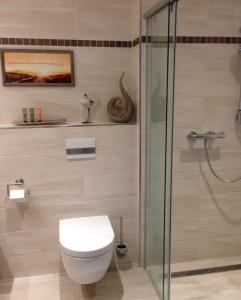 ein Bad mit einem WC und einer Dusche in der Unterkunft Lindenpalais Wohnung 24 in Heiligendamm