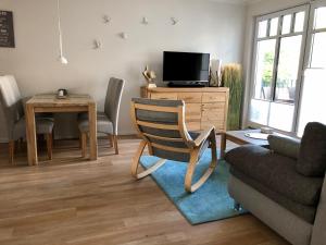 ein Wohnzimmer mit einem Sofa, einem Stuhl und einem Tisch in der Unterkunft Lindenpalais Wohnung 24 in Heiligendamm