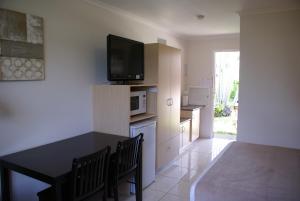 麦凯麦凯汽车旅馆的客厅配有桌子,墙上配有电视