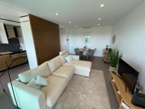 ein Wohnzimmer mit einem weißen Sofa und einem TV in der Unterkunft Ocean View Top Luxury New Built T1 -WPOV1 in Cabanas de Tavira