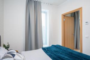 um quarto com uma cama, um espelho e uma janela em Aatrium Kinnisvara Riia str 20A apartment, 7-th floor em Tartu