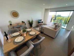 ein Wohnzimmer mit einem Tisch, Stühlen und einem Sofa in der Unterkunft Ocean View Top Luxury New Built T1 -WPOV1 in Cabanas de Tavira