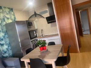 een keuken met een tafel met stoelen en een koelkast bij LM APARTAMENTOS PLAYA GRANADA Dos Mares in Motril