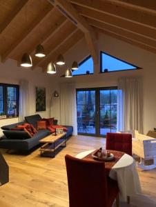 een woonkamer met een bank en een tafel bij Die Schorenmoos-Lodge in Dietmannsried