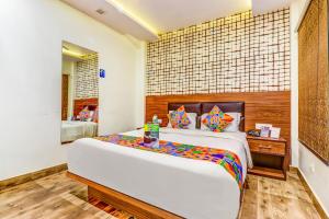 um quarto com uma cama grande e um espelho em FabHotel Sain Dass em Kanpur