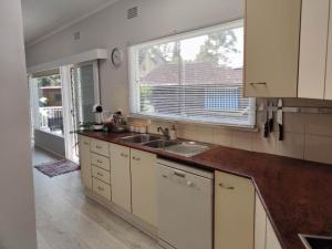 una cocina vacía con fregadero y ventana en Lake View House entire house, en Gosford