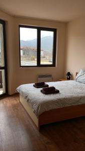 a bedroom with a bed with two towels on it at Snow Lodge Mountain view in Bansko