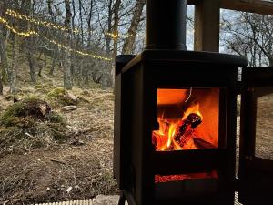 einem Holzofen mit einem Feuer auf dem Feld in der Unterkunft The Dell at Glenlivet in Glenlivet