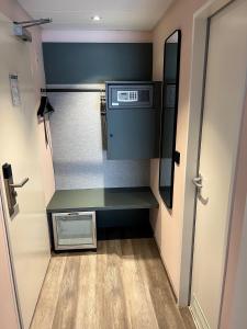 ein kleines Zimmer mit einer grünen Bank neben einer Tür in der Unterkunft Hotel Mirabell by Maier Privathotels in München