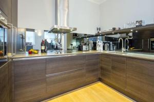 a large kitchen with wooden cabinets and stainless steel appliances at Private Patio - 2 Bedroom 2 Bathroom - Russell Sq in London