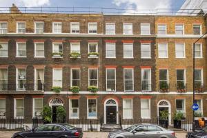 a brick building with cars parked in front of it at Private Patio - 2 Bedroom 2 Bathroom - Russell Sq in London