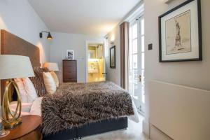 a bedroom with a bed and a table with a lamp at Private Patio - 2 Bedroom 2 Bathroom - Russell Sq in London