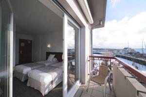 a bedroom with a bed and a balcony with a view at Hôtel Restaurant Au Lion d'Or in Burnhaupt-le-Haut