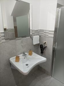 La salle de bains est pourvue d'un lavabo blanc et d'une douche. dans l'établissement Affittacamere Casa Quisquina, à Santo Stefano Quisquina