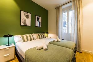 twee bedden in een kamer met groene muren bij BOULEVARD SUITE APARTMENT in San Sebastian