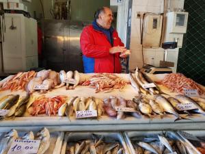 a man standing in front of a display of fish at Cyprus Villages Hotel & Restaurant - Central Location - Bed & Breakfast - With Access To Pool And Stunning Views in Tochni