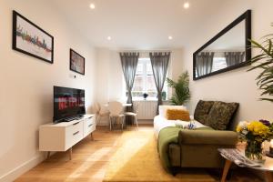 a living room with a couch and a tv at King's House by Smart Apartments in Southampton