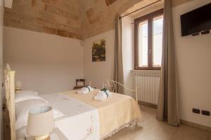 a white bedroom with a bed and a window at Al Vecchio Frantoio al Mare in Monopoli