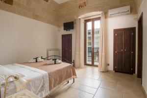 Apulianstay- Al Vecchio Frantoio al Mare في مونوبولي: غرفة نوم مع سرير وتلفزيون على الحائط