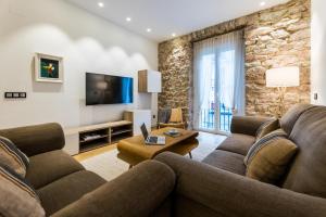 a living room with a couch and a tv at BOULEVARD SUITE APARTMENT in San Sebastián