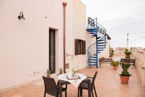 a patio with a table and chairs and a spiral staircase at Al Vecchio Frantoio al Mare in Monopoli