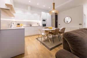 een keuken en een woonkamer met een tafel en stoelen bij BOULEVARD SUITE APARTMENT in San Sebastian