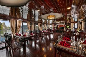 a restaurant on a cruise ship with tables and chairs at La Regina Classic Cruise in Ha Long