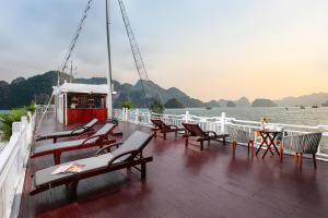 a deck of a boat with chairs and a table at La Regina Classic Cruise in Ha Long