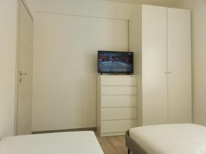 1 Schlafzimmer mit 2 Betten und einem TV an der Wand in der Unterkunft APPARTAMENTO MARIELLA - CITRA 011022-LT-166 in Porto Venere