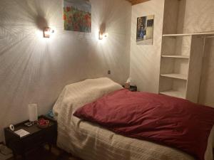 een slaapkamer met een bed en twee lampen aan de muur bij L'Escapade de JOS gite équestre in Pont-de-Salars