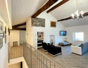 sala de estar con escalera y pared de piedra en Casa Hygge Argegno – Lake Como en Argegno