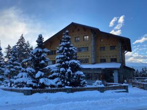 a large building with snow covered trees in front of it at Colorado Riders Chalet in Crans-Montana +37 photos