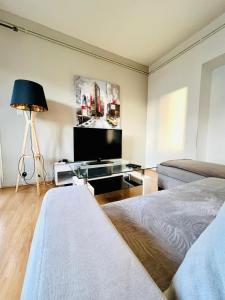 een woonkamer met 2 bedden en een flatscreen-tv bij Le Voltaire -2 chambres- 70m2- HYPERCENTRE-Parking-WIFI FIBRE in Tarbes