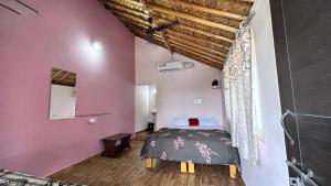 a bedroom with a bed and a pink wall at Prajwal home stay in Hampi