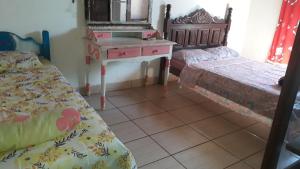 sypialnia z 2 łóżkami, komodą i lustrem w obiekcie Casa Temporada Clebinho w mieście Tiradentes