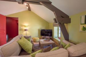 un soggiorno con un divano e una TV di Chez Joseph - Au coeur des vignes de Saint-Romain a Saint-Romain