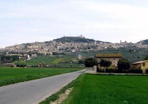 een weg die leidt naar een dorp op een heuvel bij Camere Gambacorta Assisi in Assisi