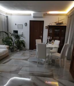 salon ze stołem i białymi krzesłami w obiekcie Casa scopelliti w mieście Calasetta