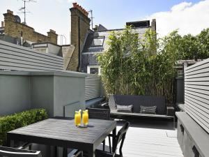 eine Terrasse mit Tisch und Getränken auf einem Balkon in der Unterkunft Flemings Mayfair - Small Luxury Hotel of the World in London