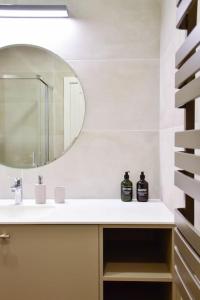 a bathroom with a sink and a mirror at Parko Aveniu Apartamentai B4 in Birštonas