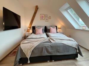 a bedroom with a bed with pink pillows and a flat screen tv at INTERGO Apartments in Brackel