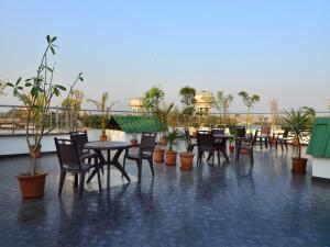 eine Terrasse mit Tischen und Stühlen auf dem Dach in der Unterkunft Hotel Shri Vinayak at New Delhi Railway Station-By RCG Hotels in Neu-Delhi